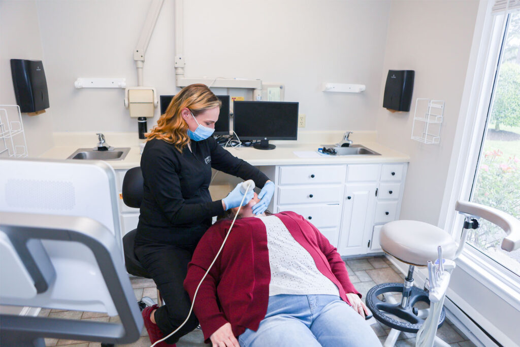 Victoria using an intraoral scanner on a patient