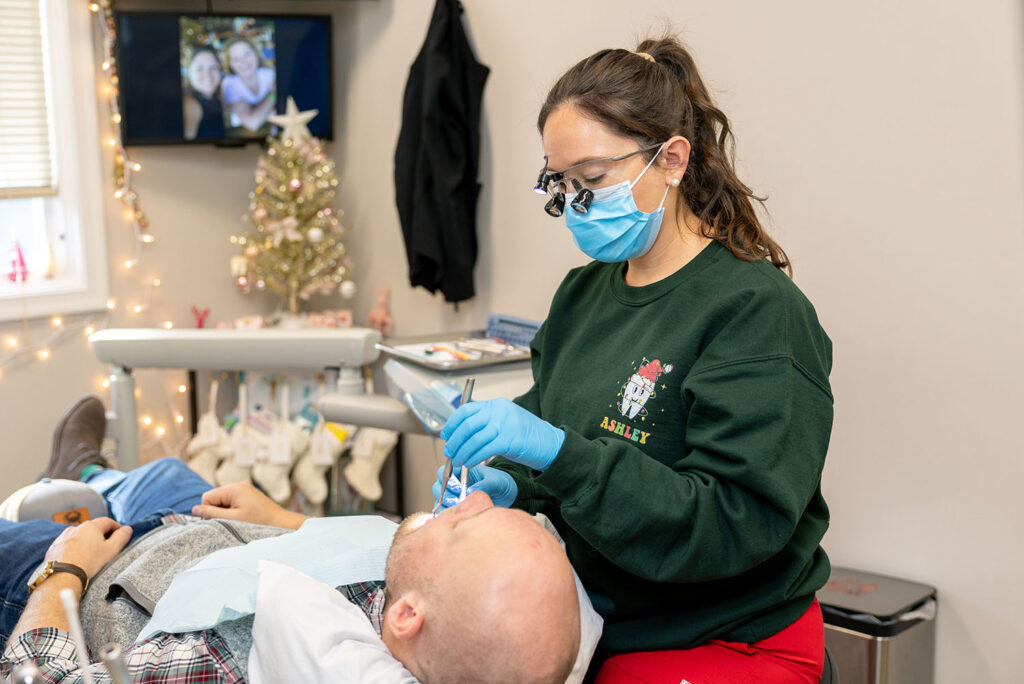 Ashley examining a patient's teeth